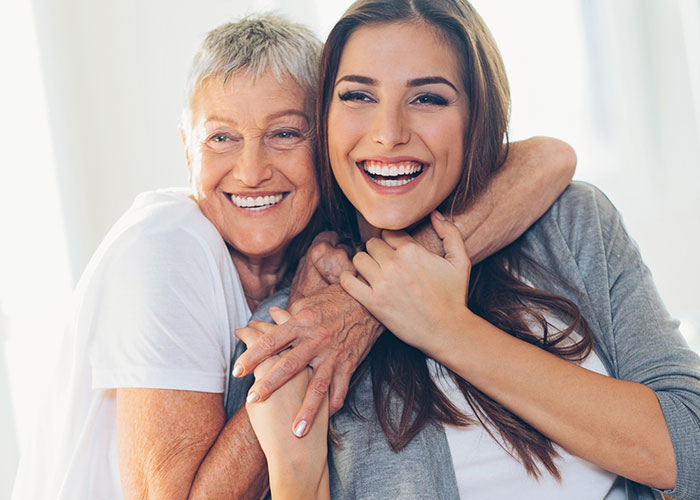 Mature mother and daughter hugging and smiling